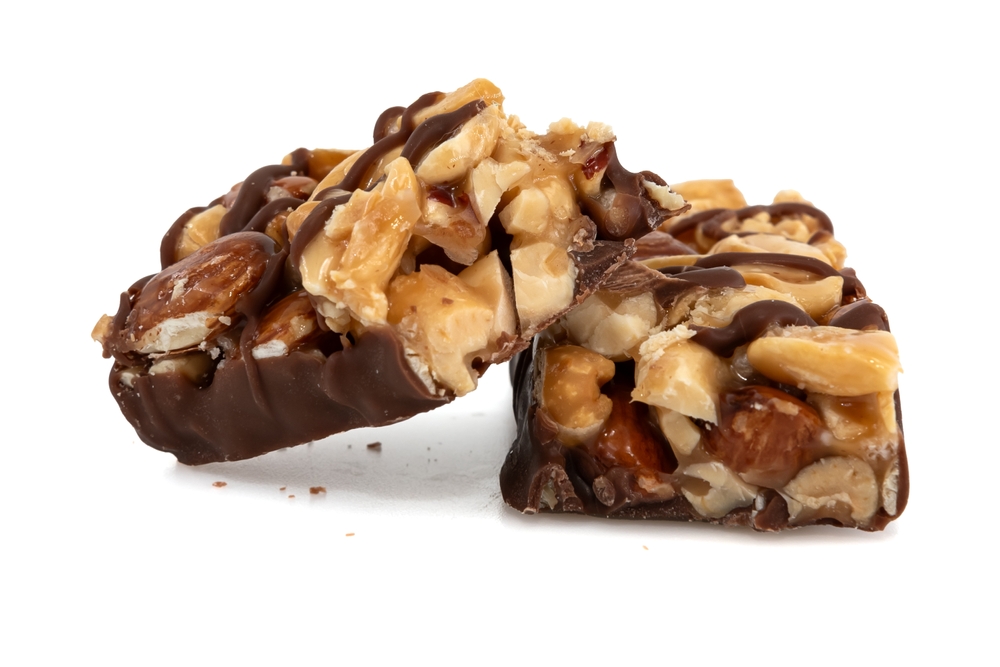 Bar,With,Peanuts,,Hazelnuts,,Caramel,And,Chocolate,On,A,White